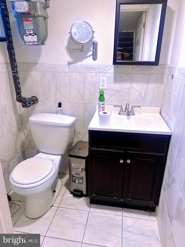 bathroom with tile walls, vanity, and toilet