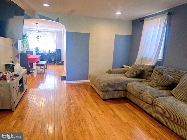 living room with light hardwood / wood-style flooring and a notable chandelier