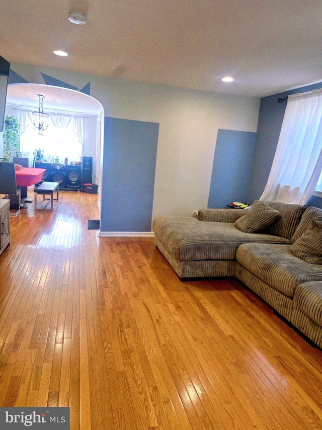 living room with light wood-type flooring and a chandelier