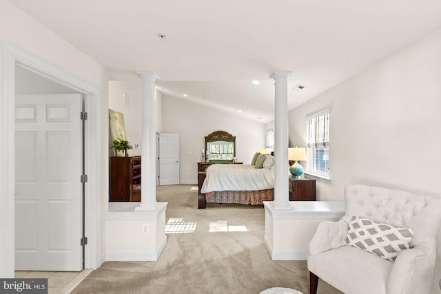 bedroom featuring lofted ceiling, decorative columns, and light carpet