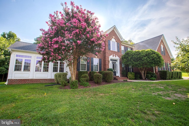 colonial home featuring a front yard