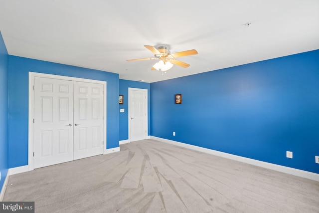 unfurnished bedroom with ceiling fan and light colored carpet