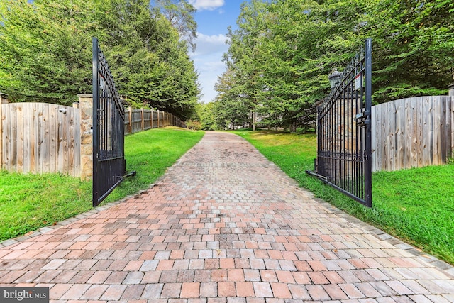 view of gate with a lawn