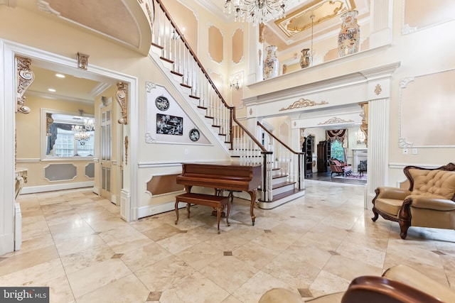 foyer entrance featuring a high ceiling, a chandelier, and crown molding