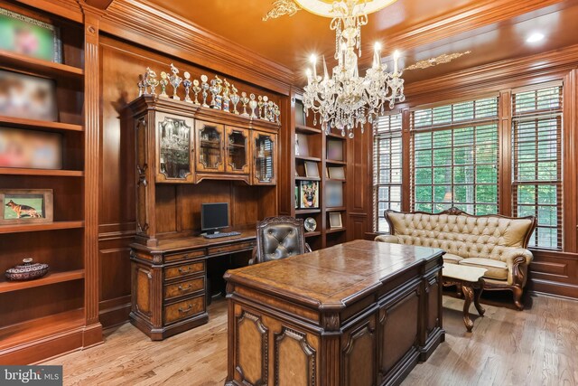 office with a notable chandelier, light wood-type flooring, built in shelves, and crown molding