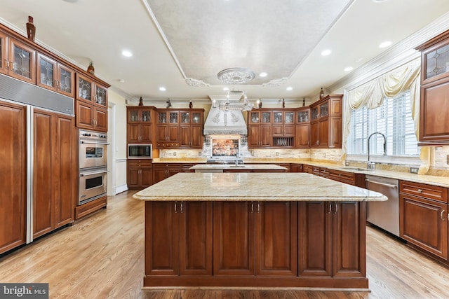 kitchen featuring light hardwood / wood-style floors, built in appliances, and a center island