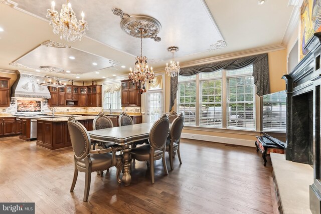 dining area with a notable chandelier, a raised ceiling, dark hardwood / wood-style floors, and ornamental molding