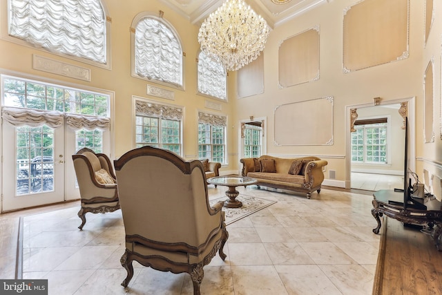 tiled living room with a high ceiling, a chandelier, and plenty of natural light