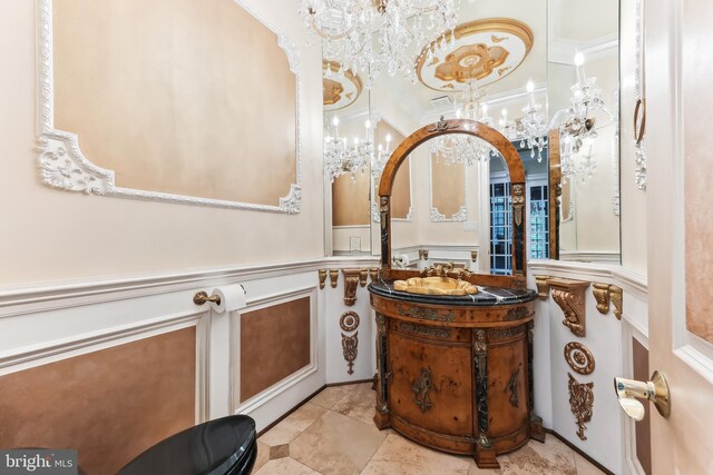 bathroom featuring crown molding, vanity, and a notable chandelier