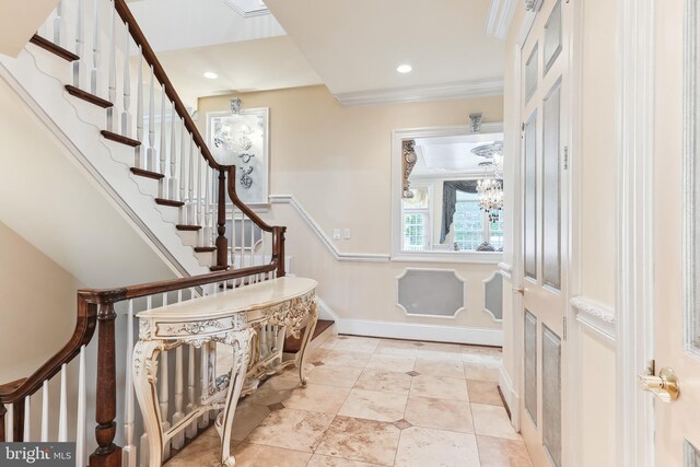 entryway with a notable chandelier and ornamental molding