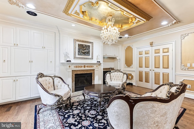 interior space with an inviting chandelier, a raised ceiling, crown molding, and hardwood / wood-style floors