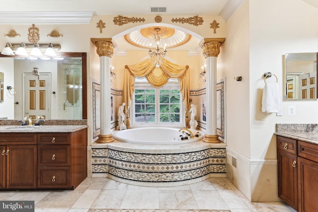 bathroom featuring tiled tub, vanity, ornate columns, and ornamental molding