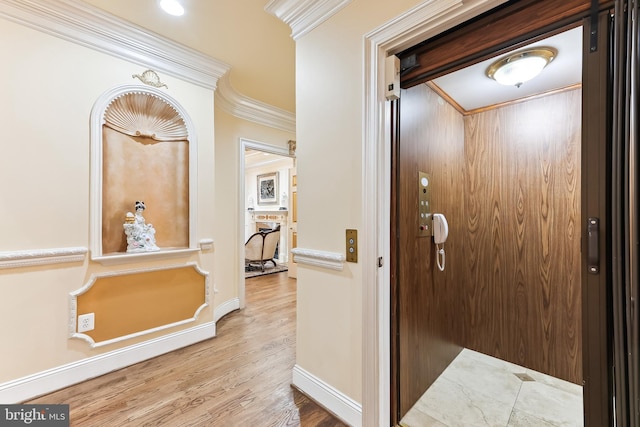 hall with ornamental molding, elevator, and hardwood / wood-style floors