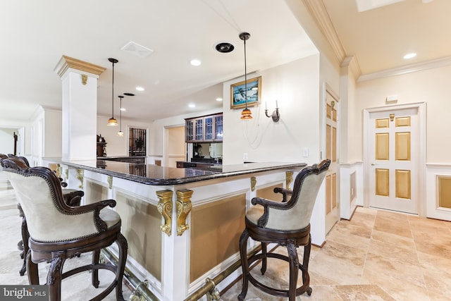 bar with dark stone counters, white cabinetry, hanging light fixtures, and crown molding