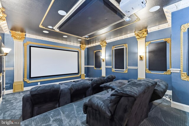 carpeted home theater room featuring a textured ceiling and decorative columns