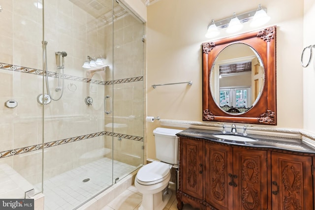 bathroom featuring vanity, toilet, an enclosed shower, and tile patterned floors