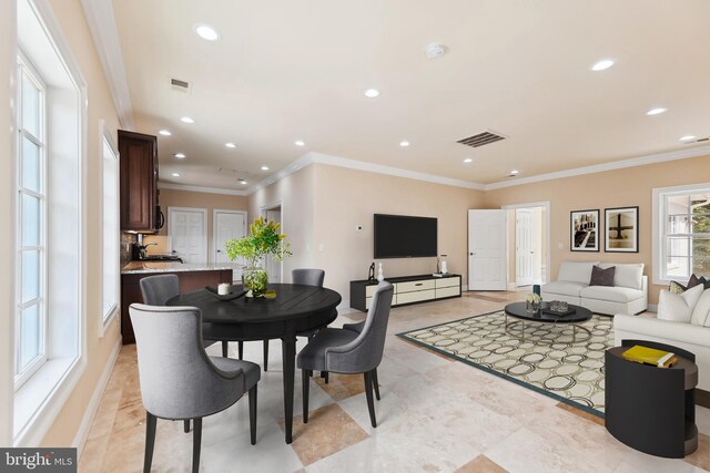 dining area with crown molding and sink