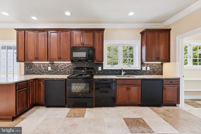 kitchen featuring black appliances, tasteful backsplash, sink, and a wealth of natural light