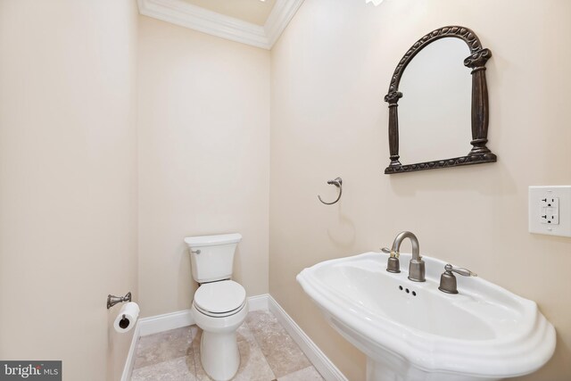 bathroom featuring ornamental molding, sink, and toilet