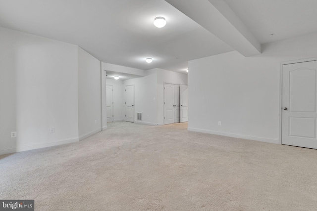 interior space with light colored carpet and beamed ceiling