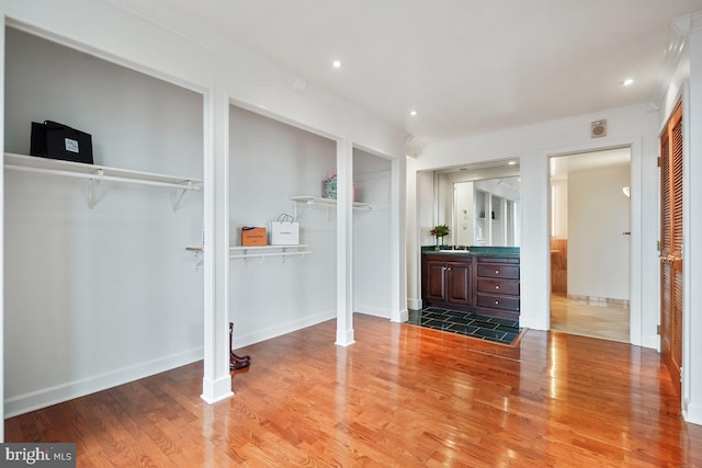 interior space with hardwood / wood-style flooring, ornamental molding, and two closets