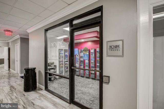 interior space featuring ornamental molding and a drop ceiling