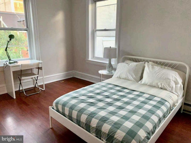 bedroom with dark hardwood / wood-style floors