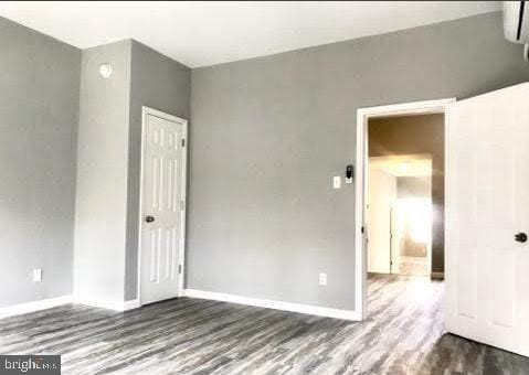 empty room with hardwood / wood-style flooring and a wall mounted air conditioner