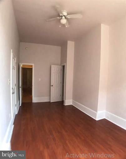 spare room with ceiling fan and dark wood-type flooring