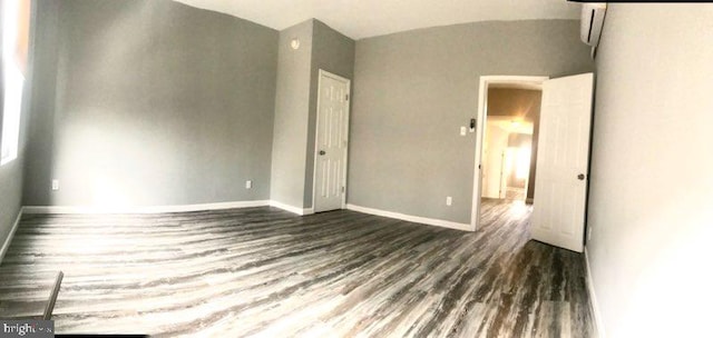 unfurnished bedroom with dark wood-type flooring and vaulted ceiling