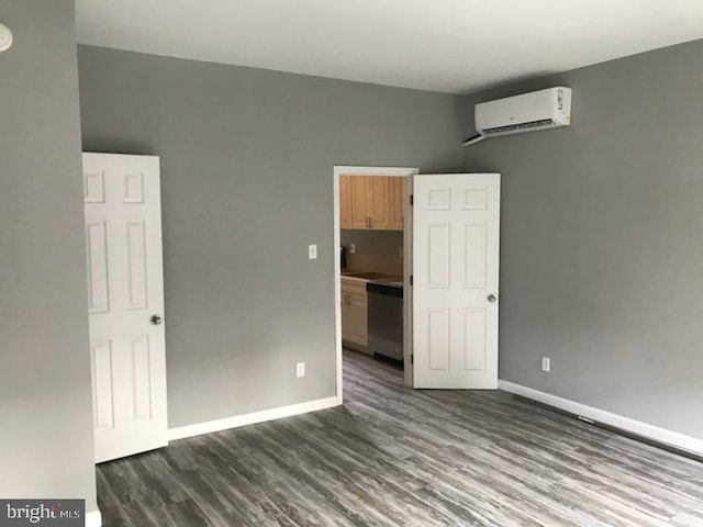 spare room featuring an AC wall unit and dark wood-type flooring