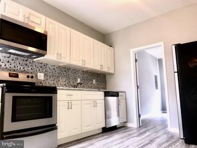 kitchen with decorative backsplash, appliances with stainless steel finishes, sink, light hardwood / wood-style floors, and white cabinetry