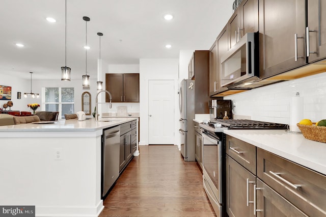 kitchen featuring dark brown cabinets, pendant lighting, sink, appliances with stainless steel finishes, and dark hardwood / wood-style flooring