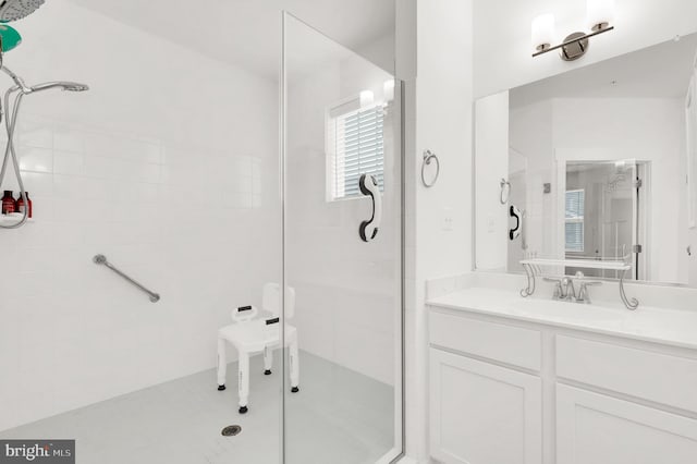 bathroom with tile patterned flooring, vanity, and a shower with shower door