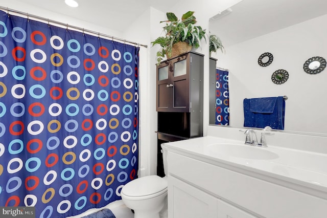 bathroom featuring a shower with shower curtain, vanity, and toilet