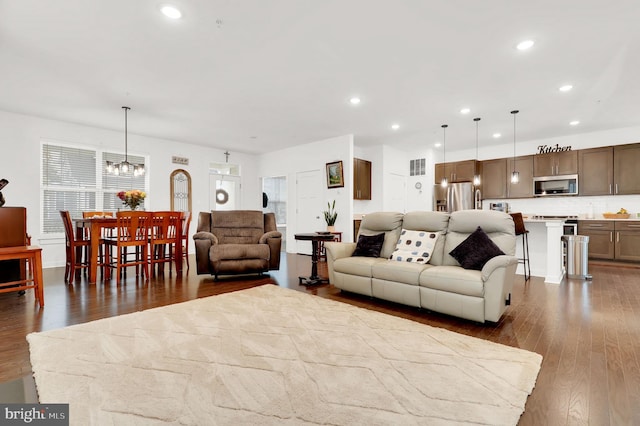 living room with an inviting chandelier and dark hardwood / wood-style floors