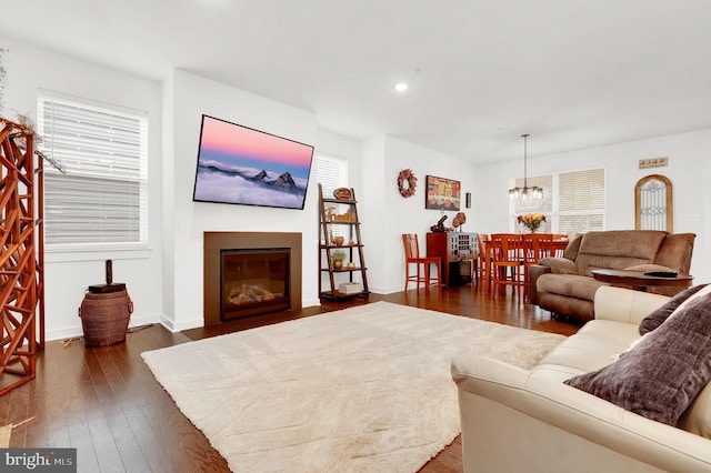 living room featuring a notable chandelier and dark wood-type flooring