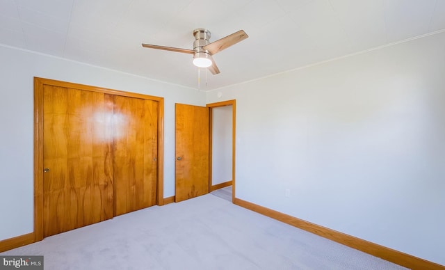 unfurnished bedroom featuring carpet flooring, ceiling fan, and a closet