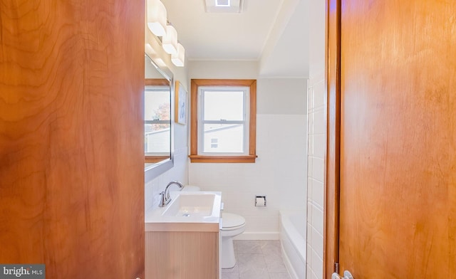 bathroom featuring vanity, toilet, ornamental molding, tile walls, and tile patterned flooring