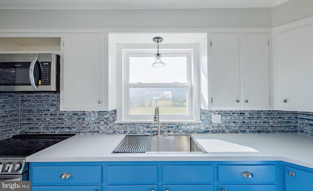 kitchen with decorative light fixtures, blue cabinets, sink, and white cabinets