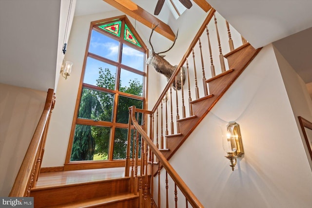 stairway featuring ceiling fan