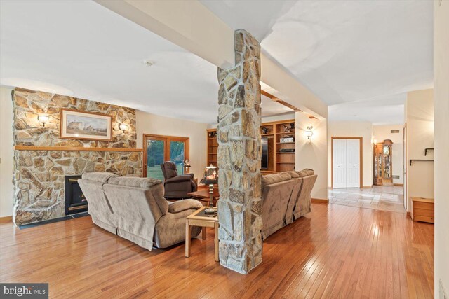 living room featuring a stone fireplace and hardwood / wood-style floors