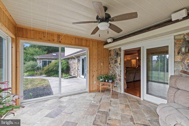 unfurnished sunroom featuring ceiling fan and plenty of natural light