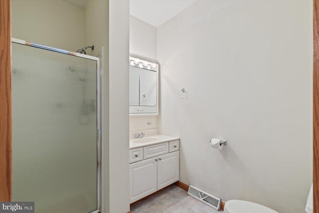 bathroom with vanity, a shower with shower door, and toilet