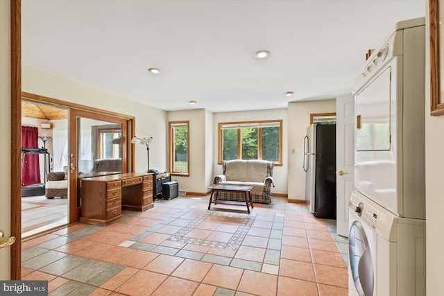 living area featuring light tile patterned floors and stacked washing maching and dryer