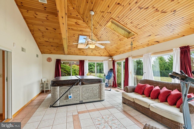 living room with ceiling fan, a skylight, light tile patterned floors, high vaulted ceiling, and wooden ceiling