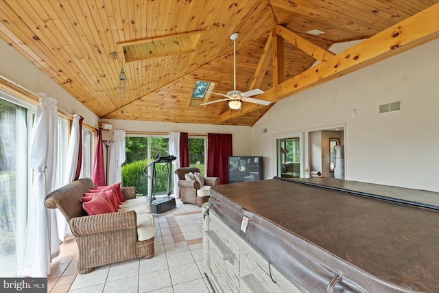 interior space featuring light tile patterned flooring, high vaulted ceiling, a skylight, ceiling fan, and wooden ceiling