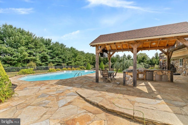 view of pool featuring an outdoor kitchen, a gazebo, and a patio area