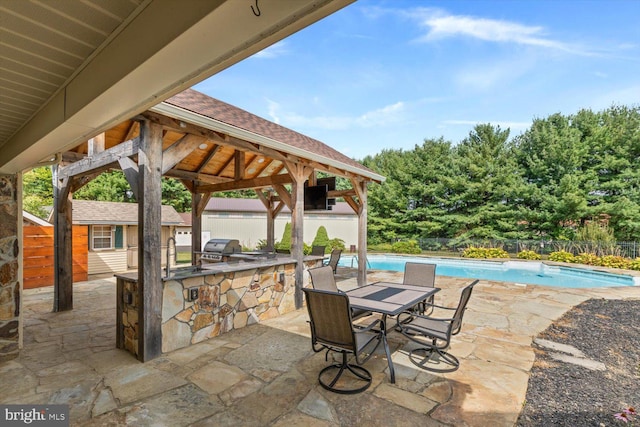 view of patio with a fenced in pool, area for grilling, and a gazebo