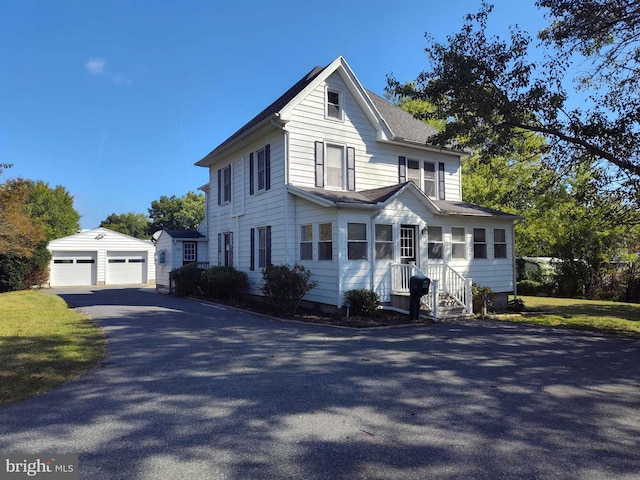 view of front of house with a garage and an outbuilding